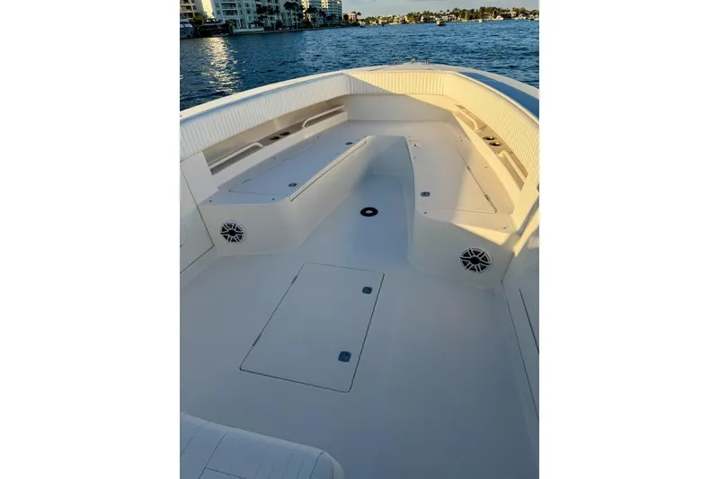 Slide: The Image of 2008 Jupiter 38 FS boat interior with seating and storage, docked by waterfront buildings. - 6