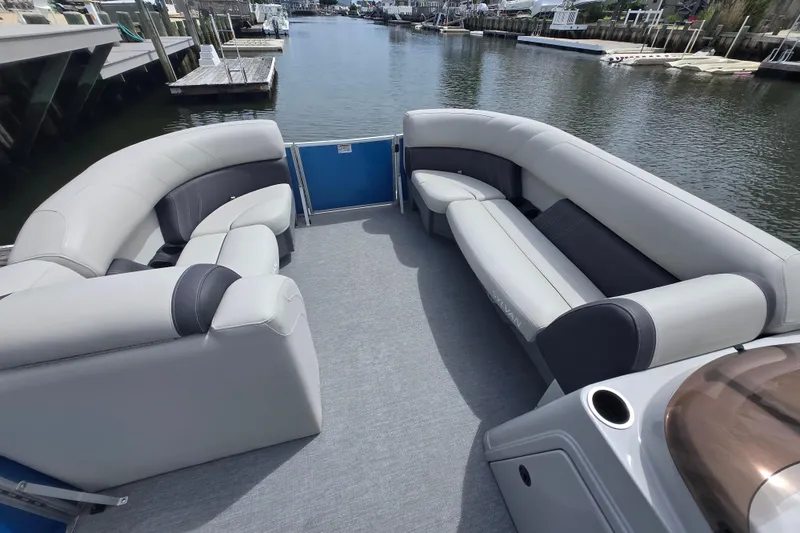 Slide: The Image of Luxurious seating on 2022 Sylvan 8522 Mirage Cruise pontoon boat, docked in a serene marina. - 10