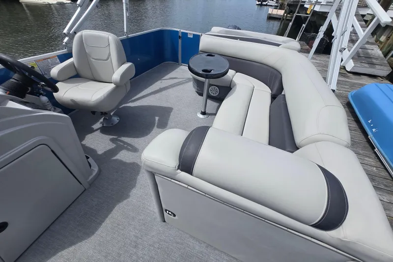 Slide: The Image of 2022 Sylvan 8522 Mirage Cruise pontoon boat interior with plush seating and steering console. - 13
