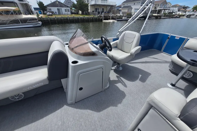 Slide: The Image of 2022 Sylvan 8522 Mirage Cruise pontoon boat interior with helm and seating. - 14