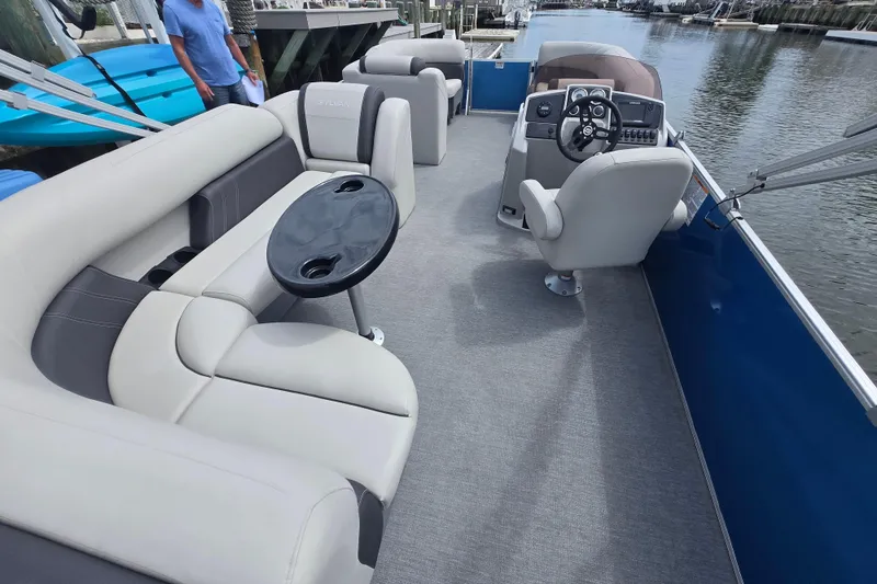 Slide: The Image of 2022 Sylvan 8522 Mirage Cruise pontoon boat interior with seating and steering console. - 8