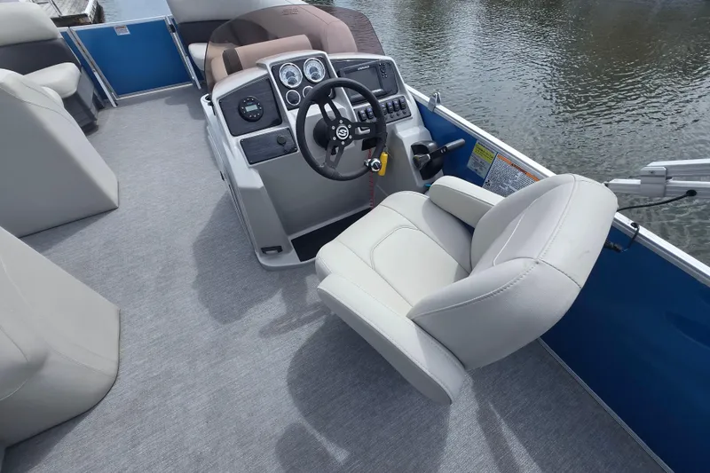 Slide: The Image of 2022 Sylvan 8522 Mirage Cruise boat interior with steering console and comfortable seating. - 9