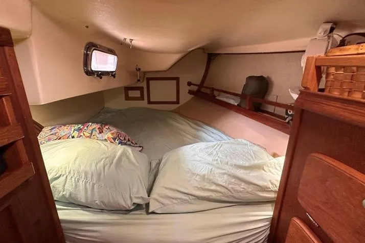 Slide: The Image of Cozy cabin interior of 1989 Island Packet 35 sailboat with bed and wooden storage. - 11