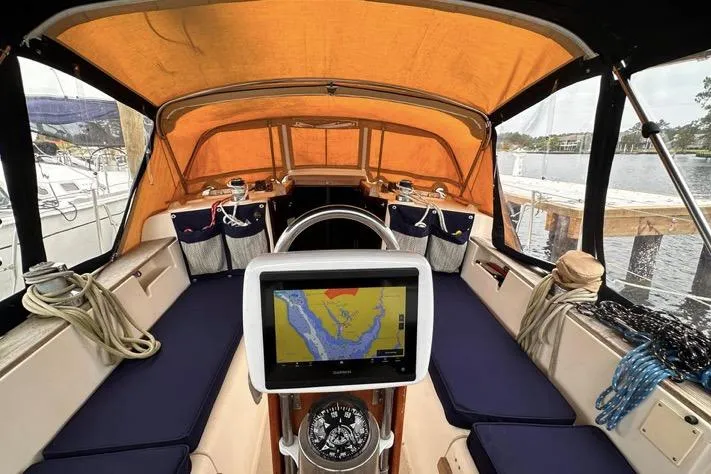 Slide: The Image of 1989 Island Packet 35 sailboat cockpit with navigation system and orange canopy. - 4