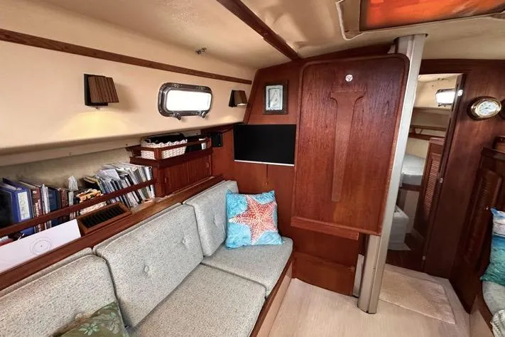 Slide: The Image of Cozy interior of 1989 Island Packet 35 sailboat with wooden accents and comfortable seating. - 7