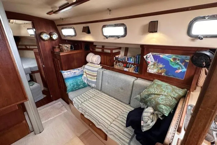 Slide: The Image of Interior of a 1989 Island Packet 35 sailboat with cozy seating and nautical decor. - 8