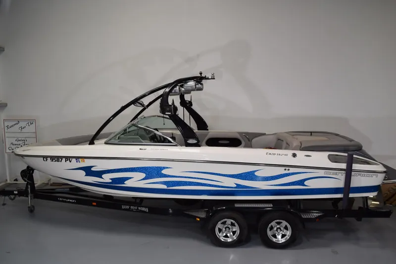 Slide: The Image of 2007 Centurion SV 240 boat with blue wave design on trailer in showroom. - 2