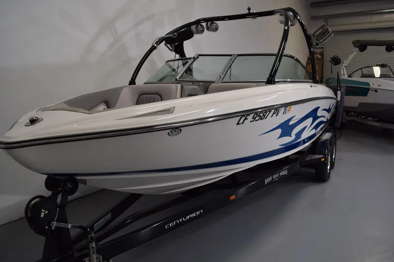 Slide: The Image of 2007 Centurion SV 240 boat with blue graphics on trailer in showroom. - 3