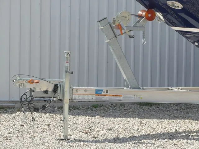Slide: The Image of Regal 2500 boat trailer, 2015 model, on gravel surface near metal wall. - 9