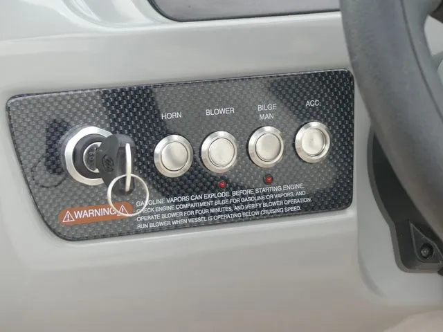 Slide: The Image of Dashboard of 2023 Chaparral 21 Surf with switches and warning label. - 47