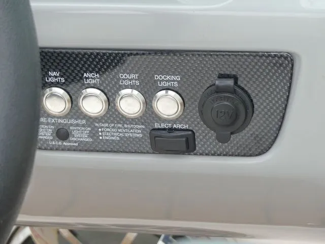 Slide: The Image of Control panel of 2023 Chaparral 21 Surf with light switches and 12V outlet. - 48