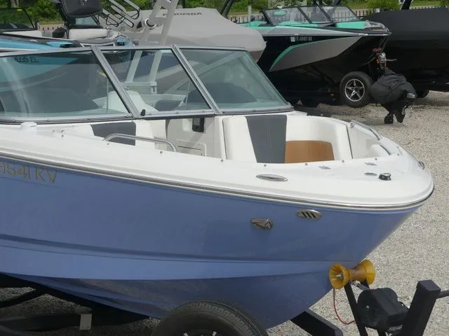 Slide: The Image of 2023 Chaparral 21 Surf boat on trailer, blue and white design. - 5