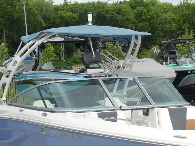 Slide: The Image of 2023 Chaparral 21 Surf boat with blue canopy in harbor. - 6