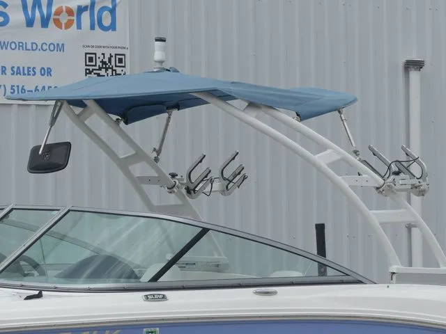 Slide: The Image of 2023 Chaparral 21 Surf boat with blue canopy and fishing rod holders. - 7