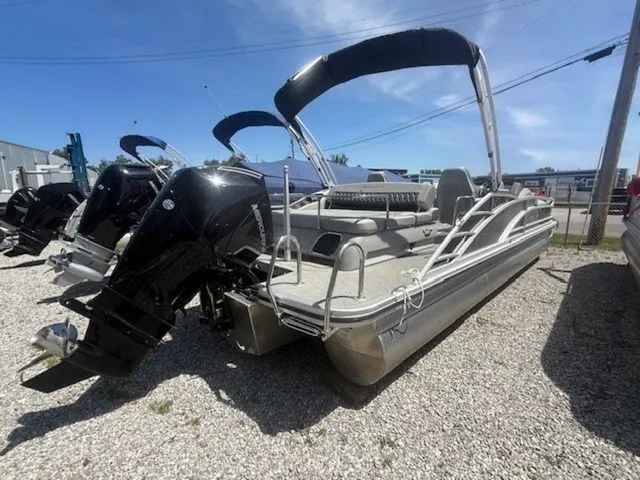 Slide: The Image of 2023 Bennington 25 RTSB pontoon boat parked on gravel lot. - 6