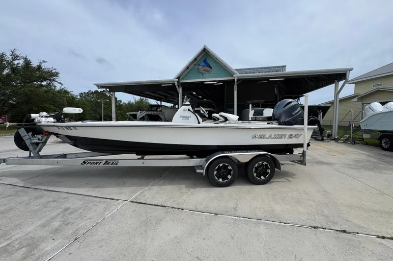 The Image of 2021 Blazer Bay 2220 GTS boat on trailer, parked outdoors near a covered structure. - 1