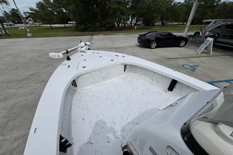 Slide: The Image of 2021 Blazer Bay 2220 GTS boat in parking lot, featuring spacious deck and trolling motor. - 17