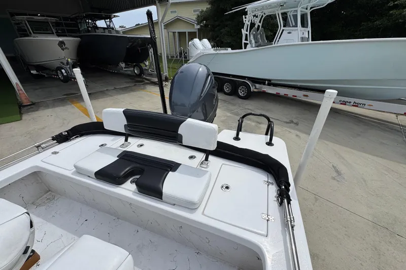 Slide: The Image of 2021 Blazer Bay 2220 GTS boat interior with motor, docked near other boats. - 29
