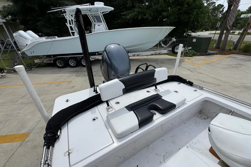 Slide: The Image of 2021 Blazer Bay 2220 GTS boat interior with seating and motor, parked near another boat. - 31