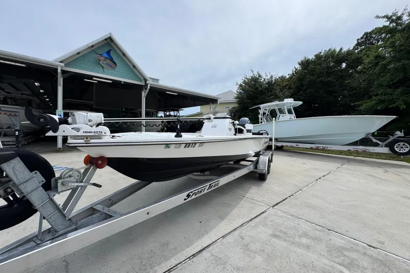 Slide: The Image of 2021 Blazer Bay 2220 GTS boat on trailer at marina, with another boat in background. - 4