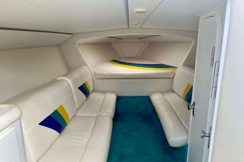 Slide: The Image of Interior of 1995 Wellcraft Scarab 31 boat with white seating and colorful accents. - 12