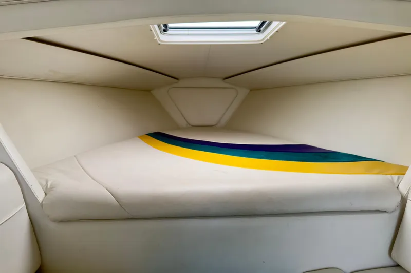 Slide: The Image of 1995 Wellcraft Scarab 31 cabin interior with colorful striped bedding. - 14