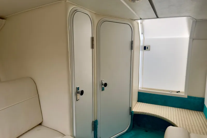 Slide: The Image of Interior of 1995 Wellcraft Scarab 31 boat, featuring white and teal seating. - 16