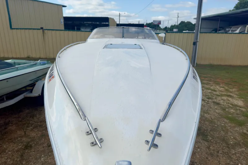 Slide: The Image of 1995 Wellcraft Scarab 31 boat, white hull, parked outdoors near a metal building. - 5