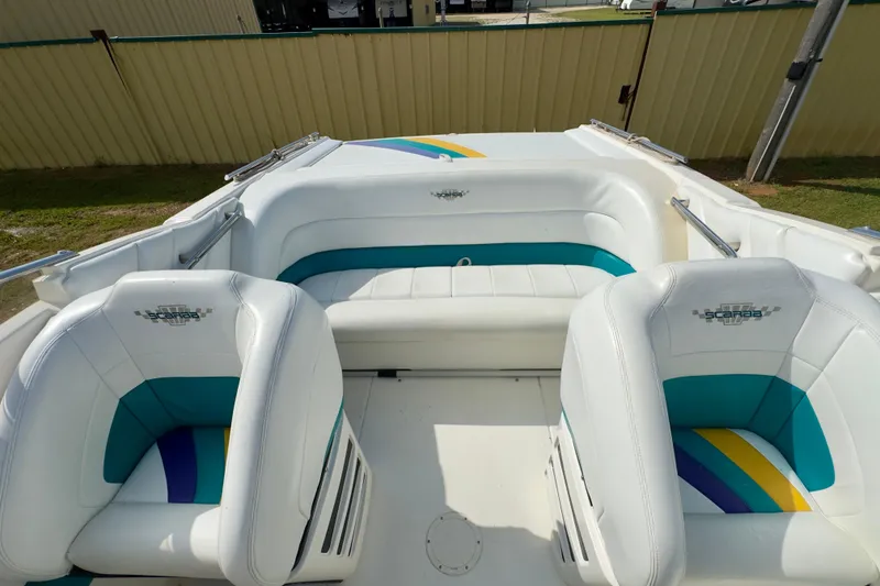 Slide: The Image of 1995 Wellcraft Scarab 31 boat interior with white and teal seating, showcasing stylish design. - 8