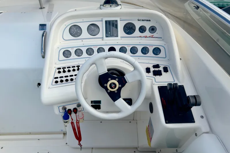 Slide: The Image of Cockpit of a 1995 Wellcraft Scarab 31 boat with steering wheel and control panel. - 9