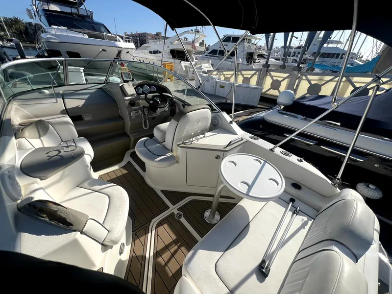 Slide: The Image of 2005 Sea Ray Sundancer boat interior with white seating and steering wheel, docked at marina. - 5