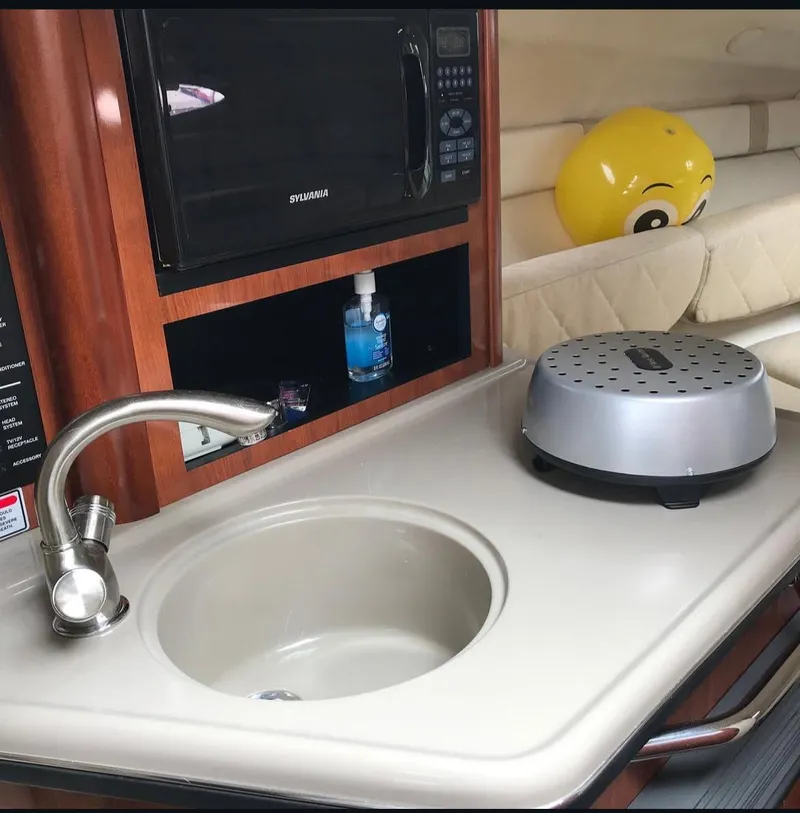 Slide: The Image of 2005 Sea Ray Sundancer yacht kitchenette with sink, microwave, and countertop appliance. - 9