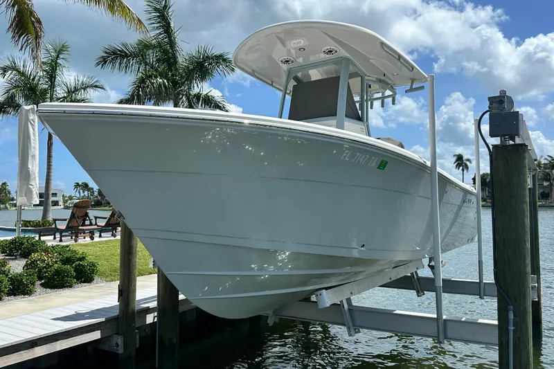 Slide: The Image of 2021 Cobia 240 Center Console boat docked near palm trees and waterfront. - 1