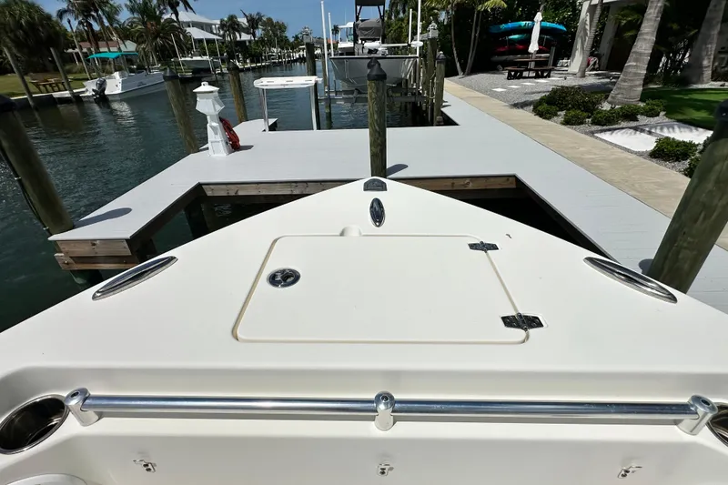 Slide: The Image of 2021 Cobia 240 Center Console boat docked at a marina with palm trees. - 11