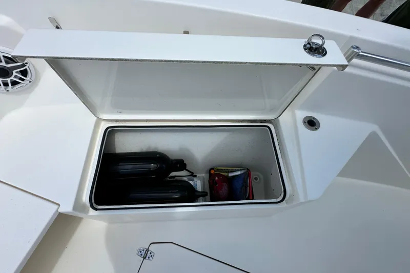 Slide: The Image of Open storage compartment on 2021 Cobia 240 Center Console boat, showing interior contents. - 15