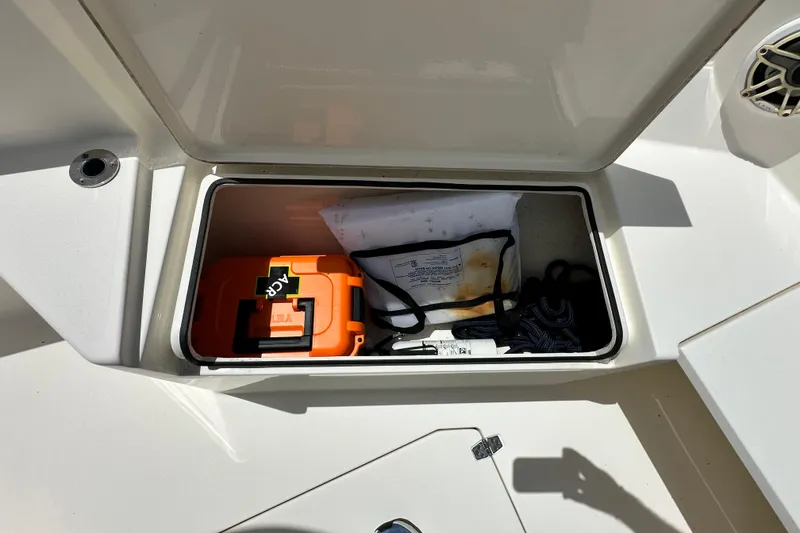 Slide: The Image of Storage compartment on a 2021 Cobia 240 Center Console boat with safety equipment. - 18