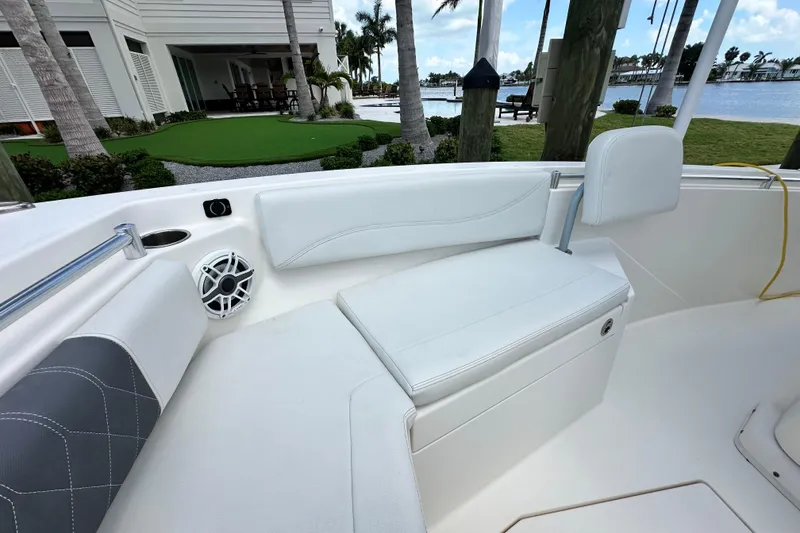 Slide: The Image of 2021 Cobia 240 Center Console boat interior with white seating and speaker. - 22