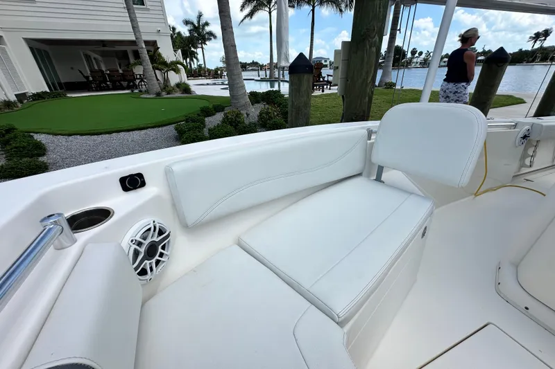 Slide: The Image of 2021 Cobia 240 Center Console boat interior with white seating and waterfront view. - 23