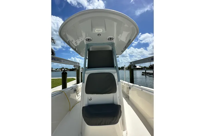 Slide: The Image of 2021 Cobia 240 Center Console boat with seating, docked by a scenic waterfront. - 29