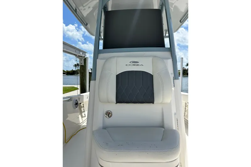 Slide: The Image of 2021 Cobia 240 Center Console boat seat with logo, under a clear blue sky. - 30