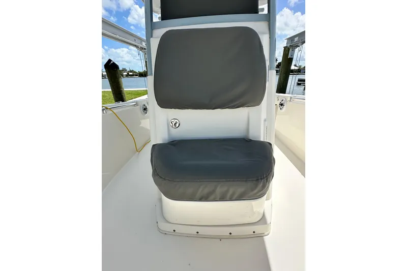 Slide: The Image of 2021 Cobia 240 Center Console boat seat with gray cushions, dockside view. - 31