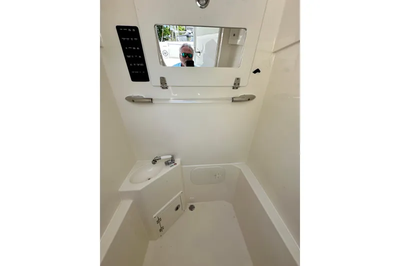 Slide: The Image of Interior of 2021 Cobia 240 Center Console boat, featuring a compact sink and mirror. - 33
