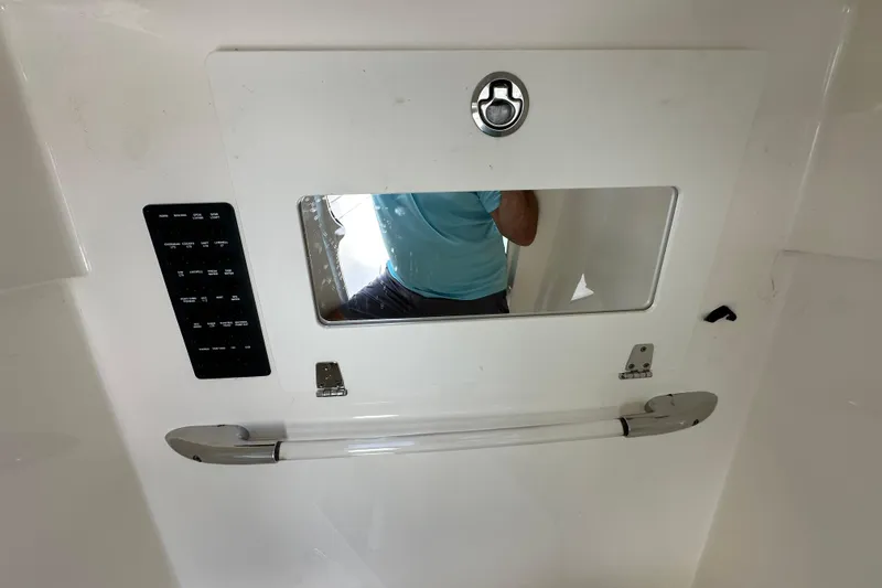 Slide: The Image of 2021 Cobia 240 Center Console interior with control panel and mirror reflection. - 34