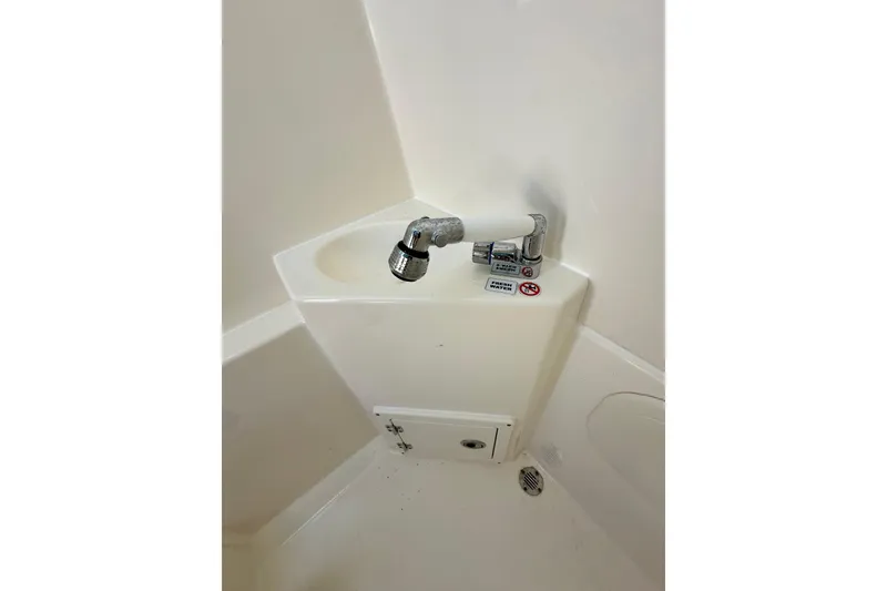 Slide: The Image of 2021 Cobia 240 Center Console boat sink with faucet in white interior. - 37