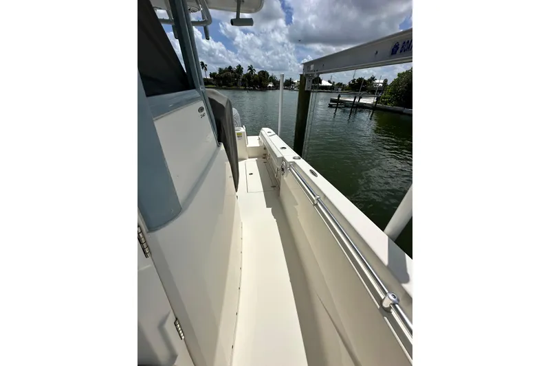 Slide: The Image of 2021 Cobia 240 Center Console boat docked by a serene waterfront. - 44
