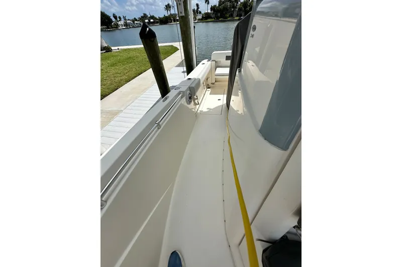 Slide: The Image of 2021 Cobia 240 Center Console boat docked by a serene waterfront. - 45