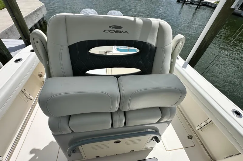 Slide: The Image of 2021 Cobia 240 Center Console boat seat with cup holders, docked by the water. - 47