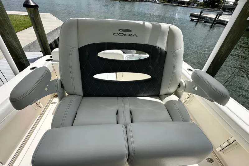 Slide: The Image of 2021 Cobia 240 Center Console boat seat with armrests, dockside view. - 48