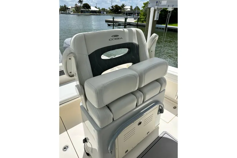 Slide: The Image of 2021 Cobia 240 Center Console boat seat with luxurious gray upholstery, dockside view. - 49