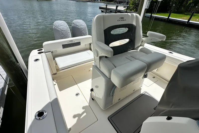 Slide: The Image of 2021 Cobia 240 Center Console boat interior with seating, docked by the water. - 51